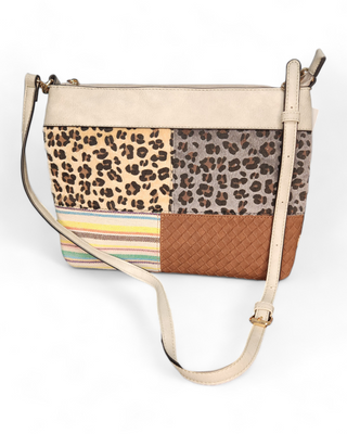 A patchwork crossbody bag with various animal prints, woven textures, and colorful stripes on the front, and a cow print on the back, featuring a beige top section and an adjustable strap.