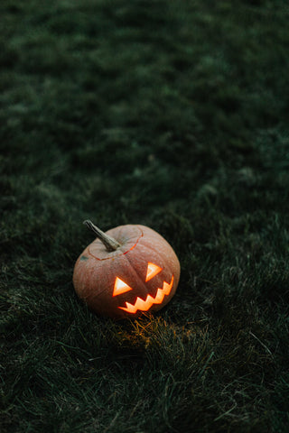 Jack o Lantern on grass. Photo by Karolina Grabowska