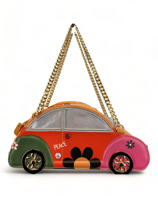 Novelty handbag shaped like a VW Beetle, orange with green and pink accents, polka dots, a peace sign, and a gold chain strap.