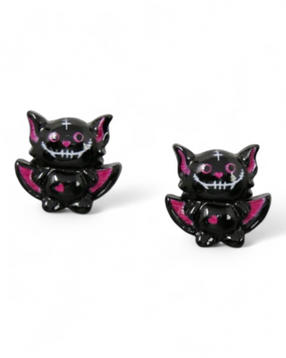 Black cat figurines with pink accents on a white background