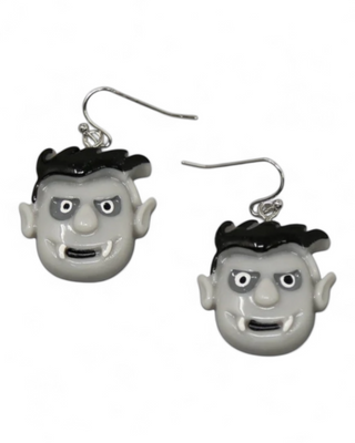 Pair of earrings with character face designs on a white background