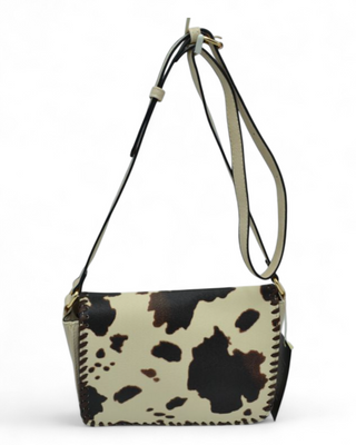 Cow print handbag with a strap on a white background