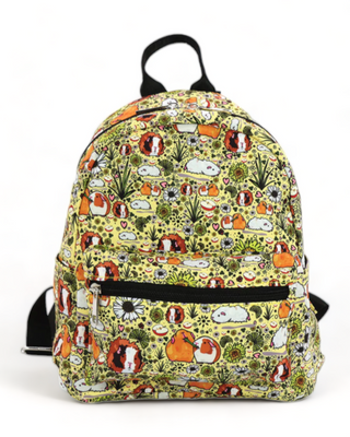 A vibrant yellow backpack featuring a whimsical guinea pig print amidst a pattern of greenery and daisies, with black zippers and straps.
