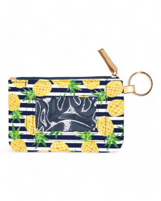 extile ID holder decorated with a vibrant pineapple pattern on navy stripes, equipped with a gold ring for keys and a clear front pocket for ID display.