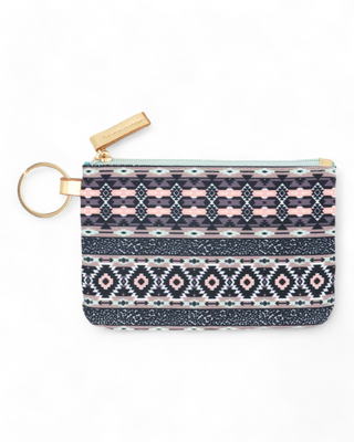 Textile ID holder with a rich tribal pattern in shades of blue,  pink and coral, equipped with a gold ring for keys and a clear front pocket for displaying identification cards.