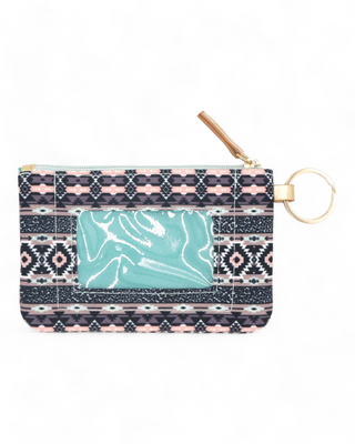 Textile ID holder with a rich tribal pattern in shades of blue,  pink and coral, equipped with a gold ring for keys and a clear front pocket for displaying identification cards.
