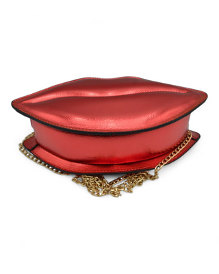 Red lip-shaped handbag with a gold chain on a white background
