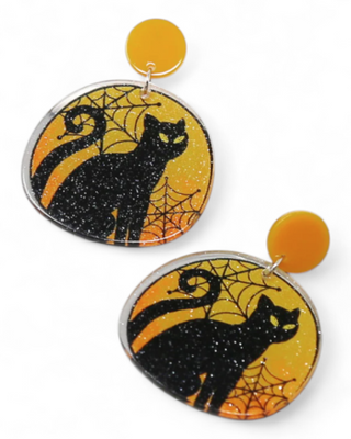 Halloween-themed earrings with black cats and spider webs on a yellow background.
