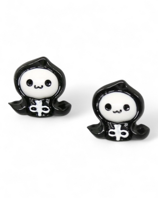 Two black and white ghost figurines with Halloween-themed attire on a white background