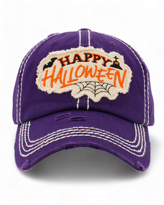 Purple baseball cap with a distressed look, featuring an embroidered patch that reads "Happy Halloween." The patch includes a spider web, a small bat, and decorative white stitching on the brim.