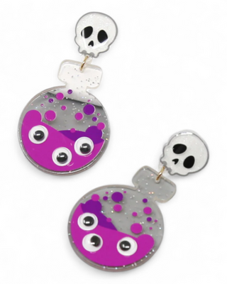 Pair of earrings with skull and eye design on a white background