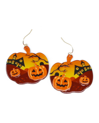 A pair of Halloween-themed earrings, featuring a detailed scene with jack-o'-lanterns in front of a haunted house under an orange sky