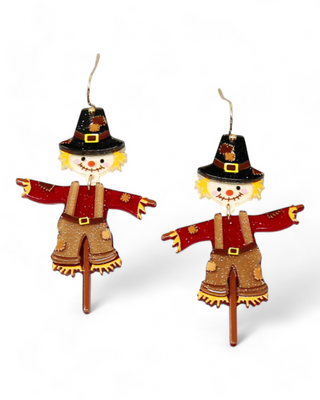 Scarecrow earrings with patchwork clothing and black hats.