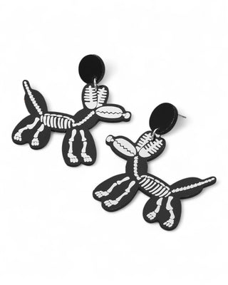 Black earrings shaped like balloon dogs with white skeleton print, post-back style.