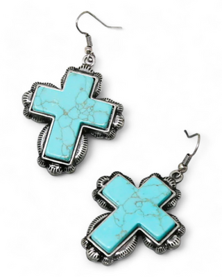 Pair of turquoise cross earrings with silver detailing and hooks.