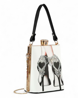 Structured clutch bag with illustration of rhinestone-embellished black high heels, top handle, and gold chain strap