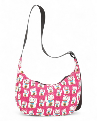  Pink shoulder bag with repeating lucky cat pattern and adjustable black strap.